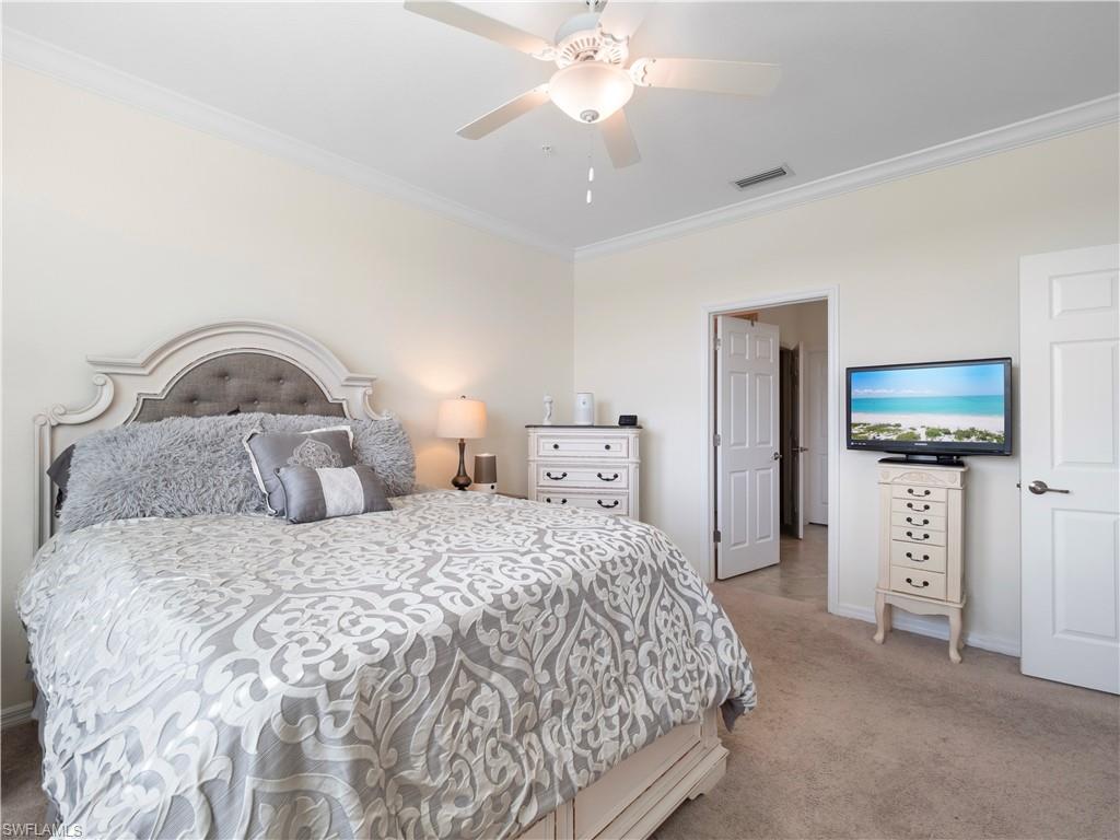 Carpeted bedroom with crown molding and a ceiling fan