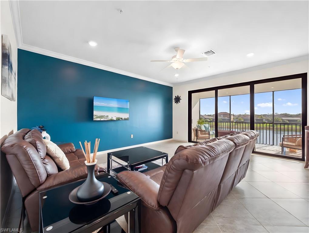 Living area featuring ceiling fan, crown molding, recessed lighting, an accent wall, and light tile patterned flooring