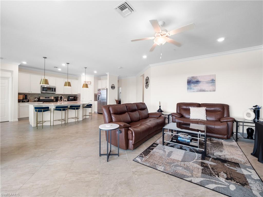 Living area featuring ornamental molding, recessed lighting, and ceiling fan