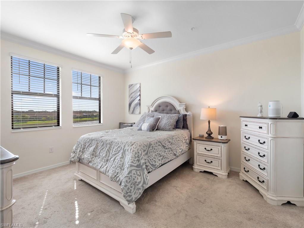 Bedroom featuring ornamental molding, light carpet, and ceiling fan
