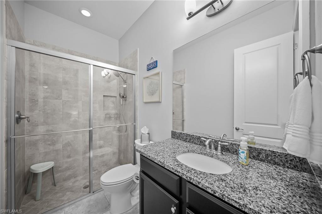 Bathroom with vanity, a shower stall, and light tile patterned floors