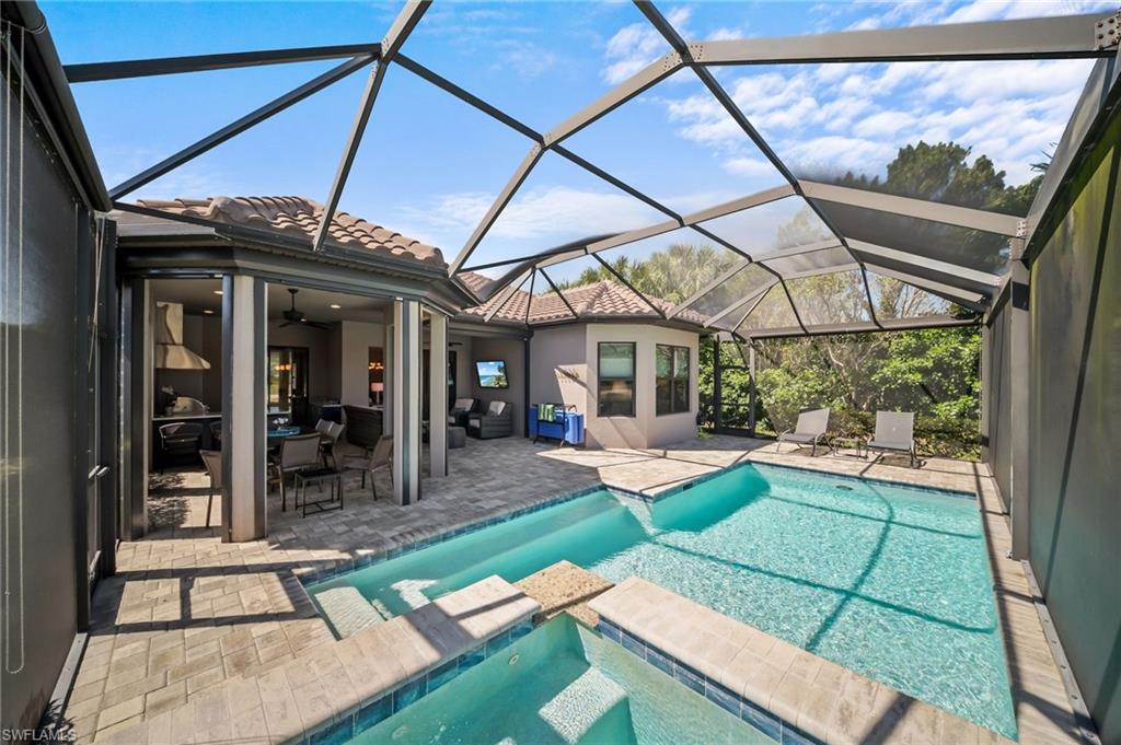 Combined pool / hot tub with a patio area, a sunroom, and a lanai