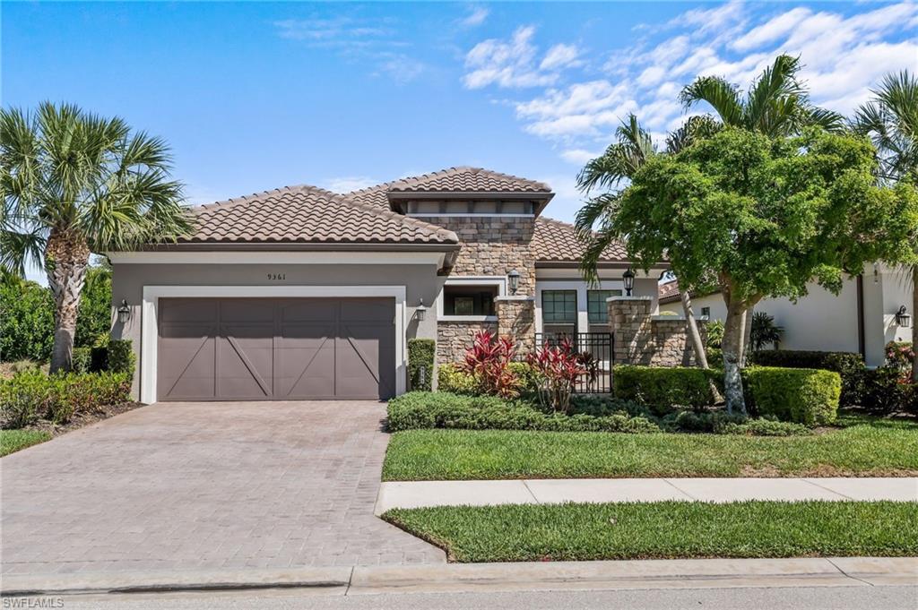 Mediterranean / spanish home with a garage, stucco siding, stone siding, decorative driveway, and a tiled roof