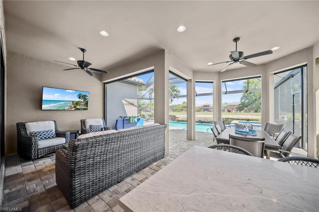 View of patio featuring a ceiling fan, a sunroom, an outdoor pool, glass enclosure, and an outdoor living / dining area