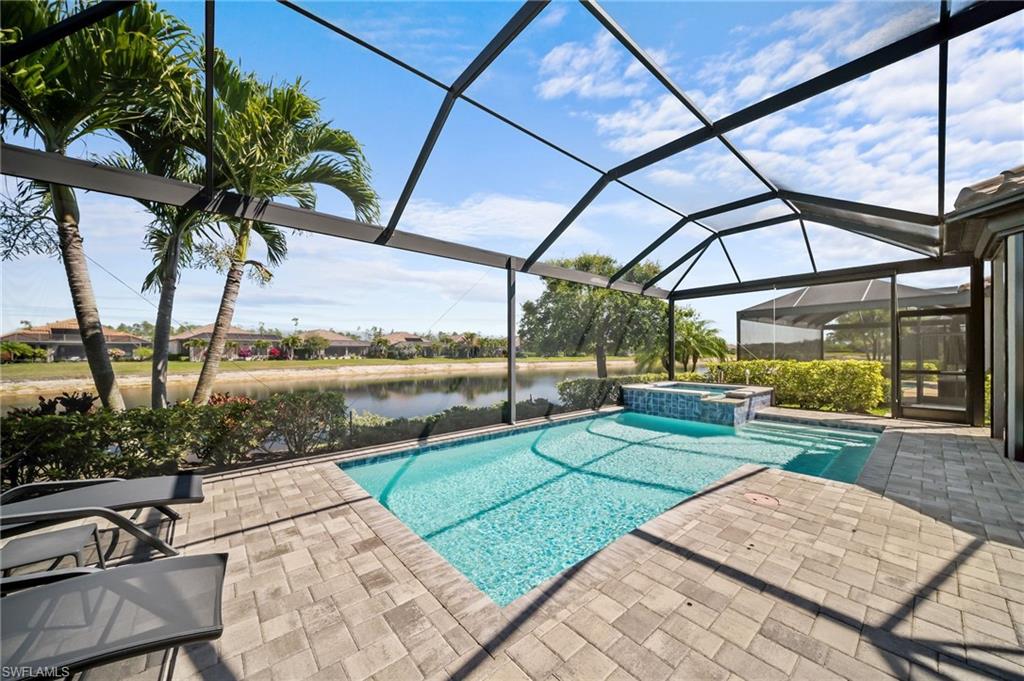 Integrated pool / spa featuring glass enclosure, a sunroom, a patio, and a water view