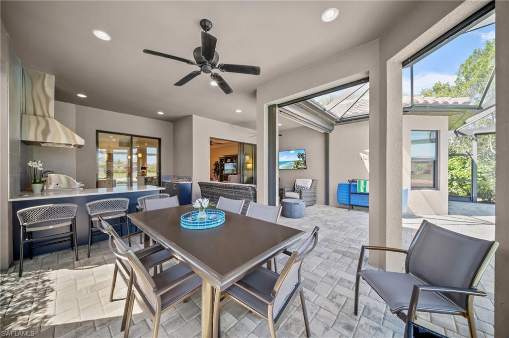 Dining area with recessed lighting, a ceiling fan, and light stone finish floors