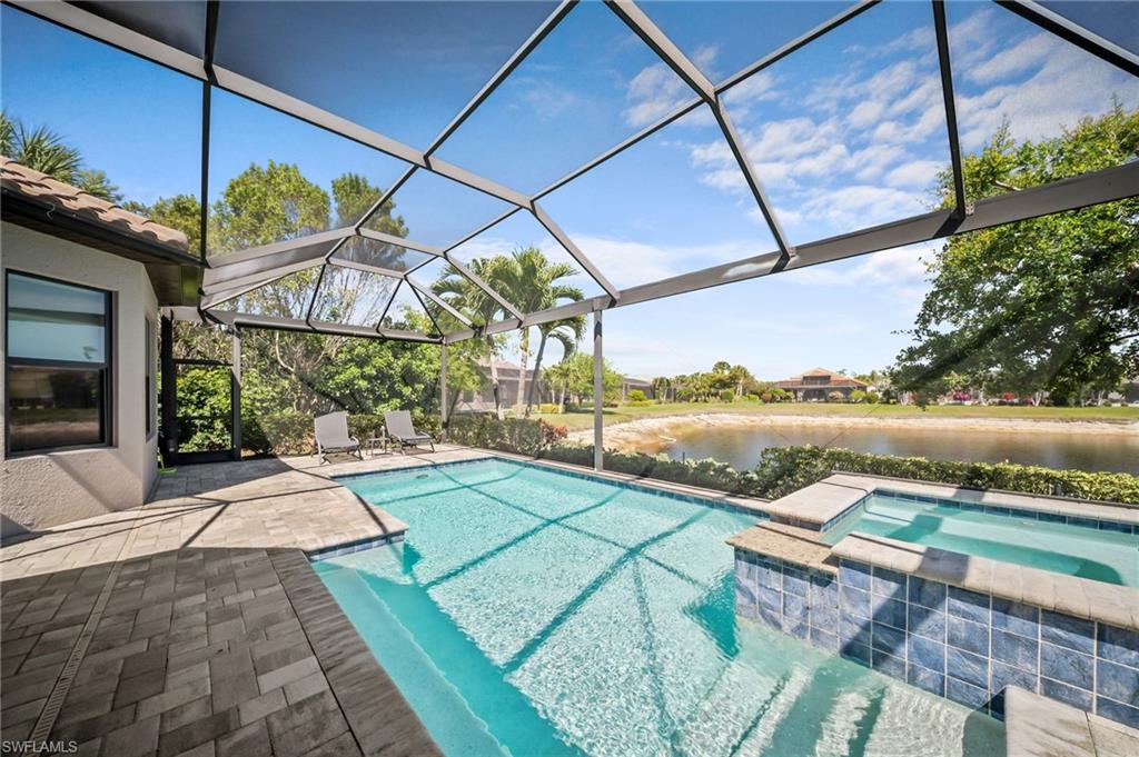 Integrated pool / spa featuring a patio, a sunroom, a lanai, and a water view