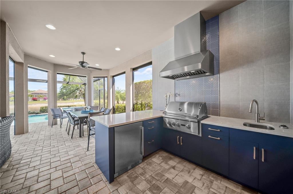 Kitchen with a peninsula, ceiling fan, stainless steel fridge, backsplash, and modern cabinets
