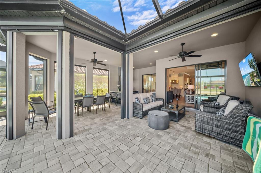 View of patio with outdoor lounge area, ceiling fan, and a sunroom