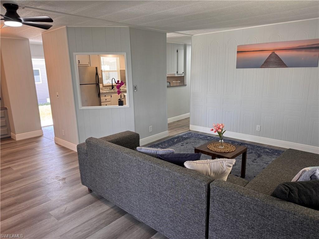 Living room view of kitchen and dining.  Decorative accent wall, laminate flooring