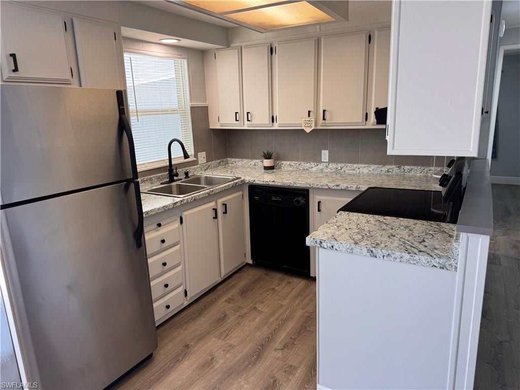 Kitchen featuring appliances, stove w/vent fan, refrigerator and dishwasher.  New sink and faucet.  Formica countertops and laminate flooring