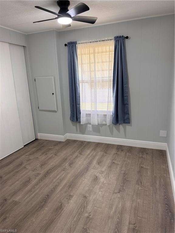 Unfurnished guest bedroom with laminate floors, a textured ceiling, a closet, and a ceiling fan