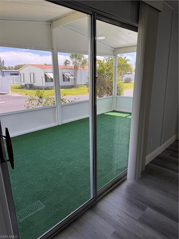 Doorway featuring laminate flooring with slider access to sunroom