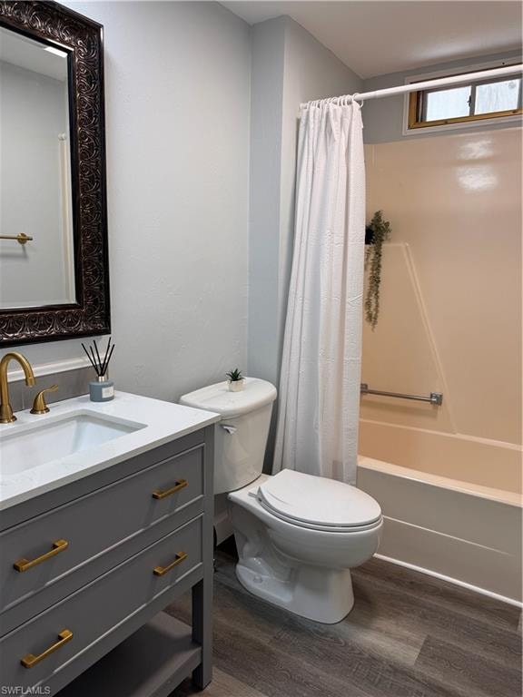 Bathroom featuring dark wood-style flooring, vanity, and shower / tub combo with curtain