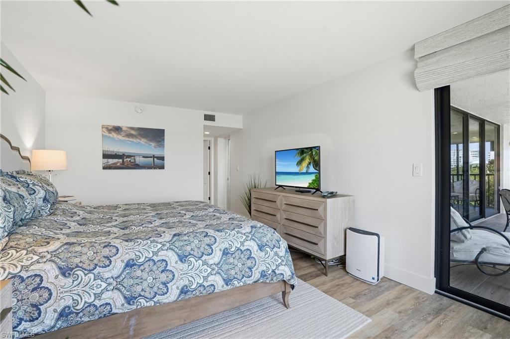 Bedroom featuring access to outside and light wood-style floors - Virtually Edited Image