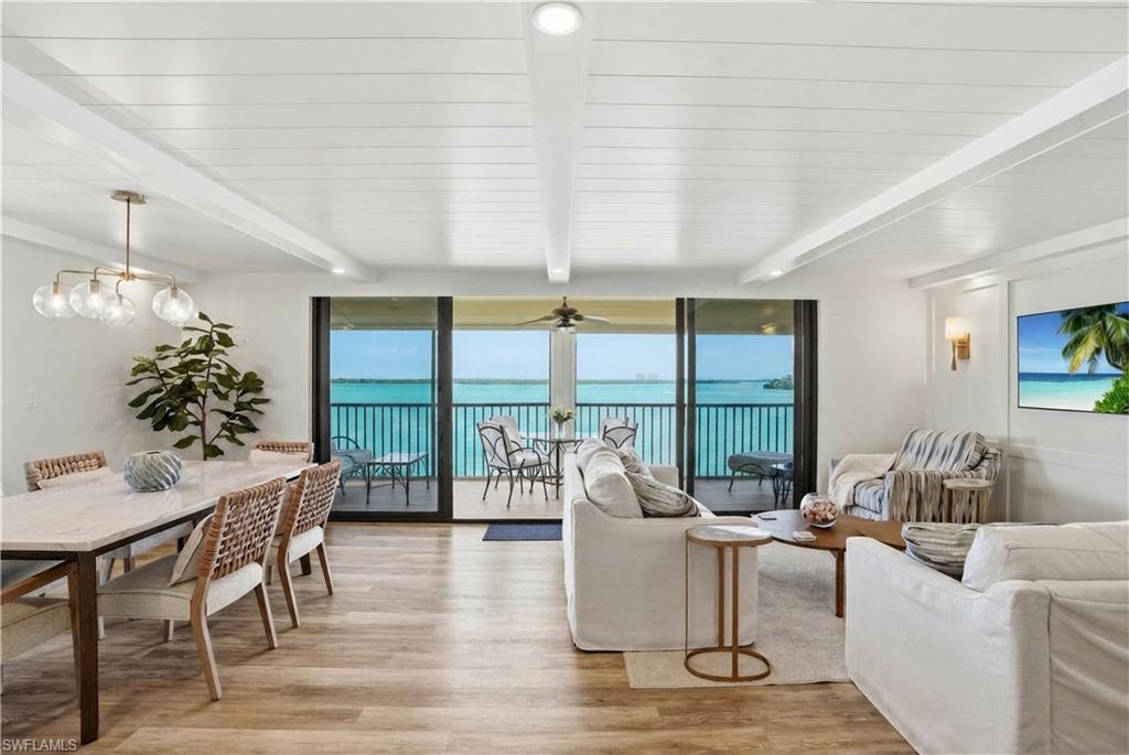 Open-concept living space with expansive water views from a private balcony - Virtually Edited Image