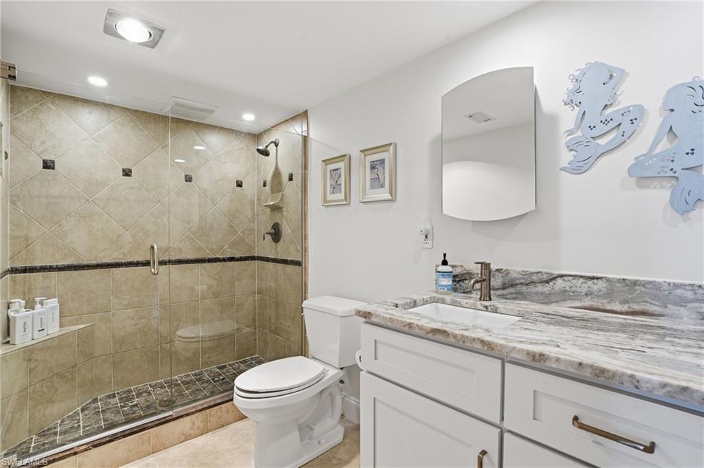Bathroom featuring vanity, a stall shower, and recessed lighting - Virtually Edited Image