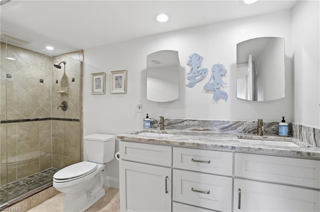 Full bath featuring double vanity, a shower stall, and recessed lighting - Virtually Edited Image