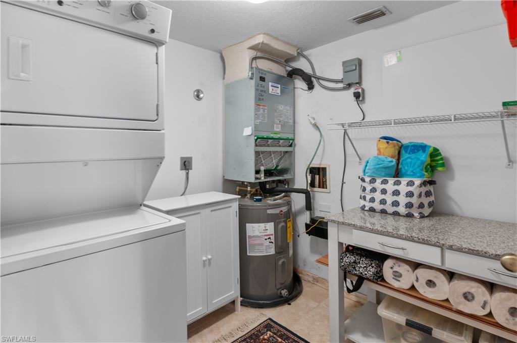 Utility room with newer A/C and stacked washer/dryer