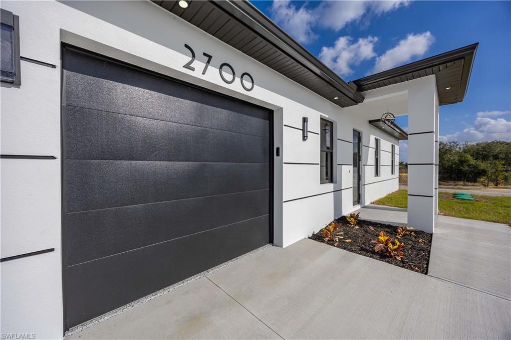 View of home's exterior with a garage, stucco siding, and driveway