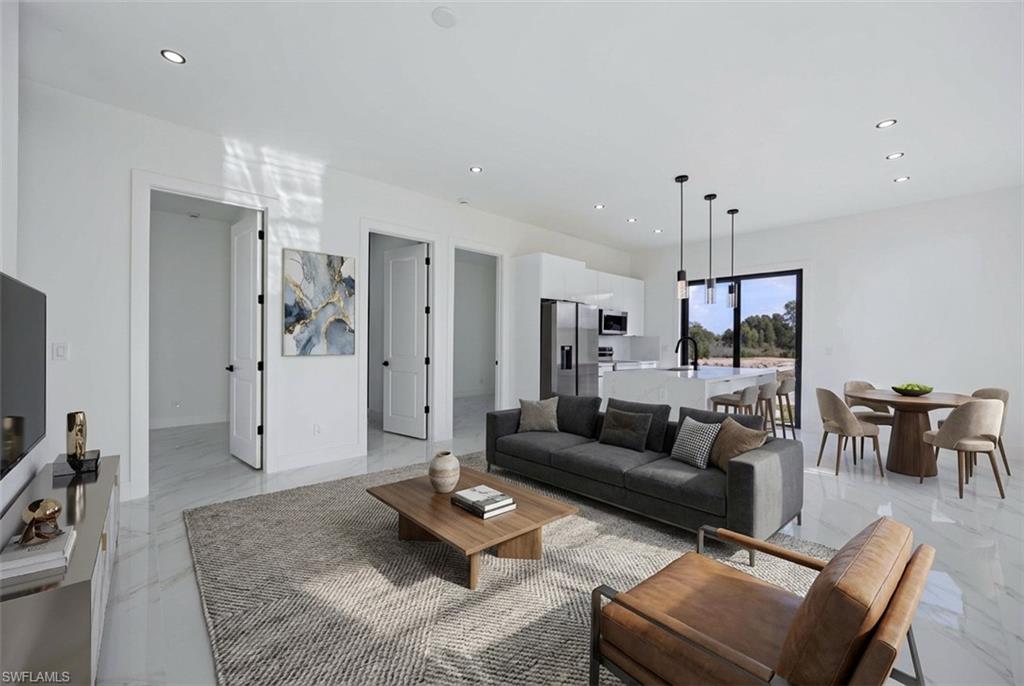 Living area featuring recessed lighting and light marble finish flooring