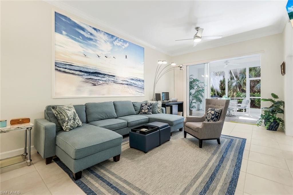Light and bright living room featuring light tile patterned floors, crown molding with view into back screened Lanai.