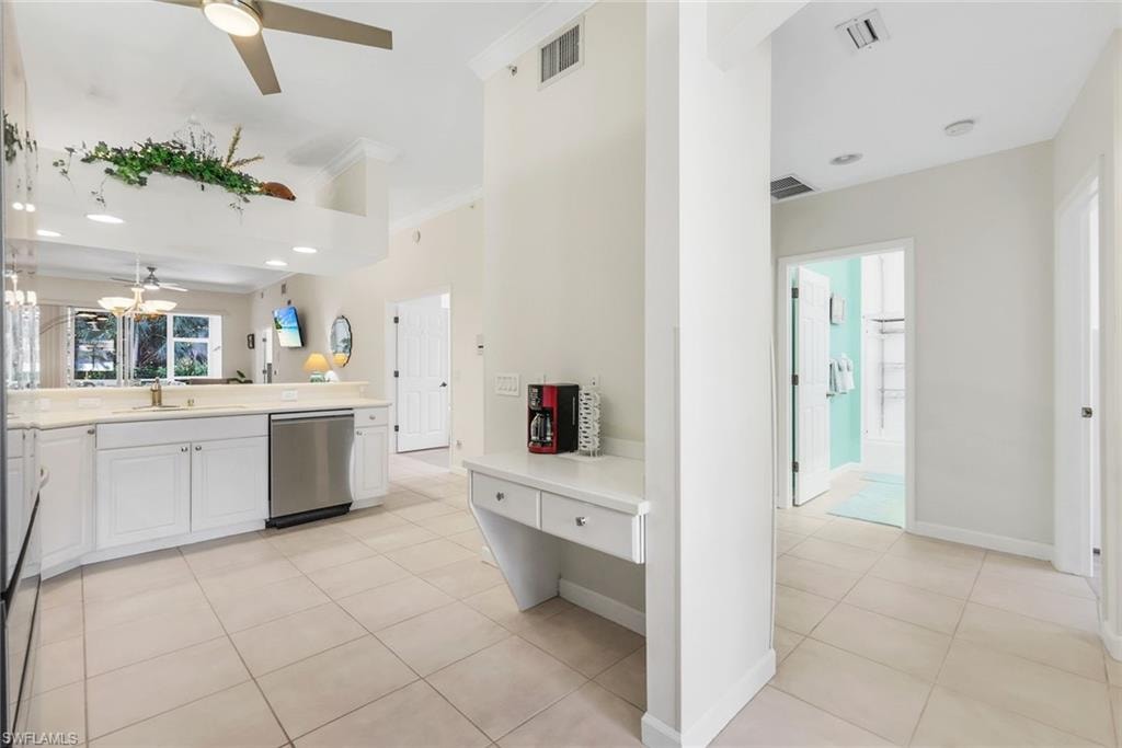 Kitchen featuring white cabinets, desk area, light tile floors, ceiling fan, dishwasher, and recessed lighting.