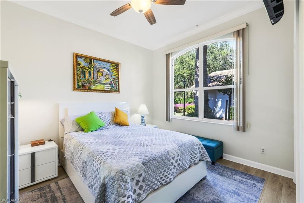 Guest bedroom featuring wood finished tile floors and ceiling fan.