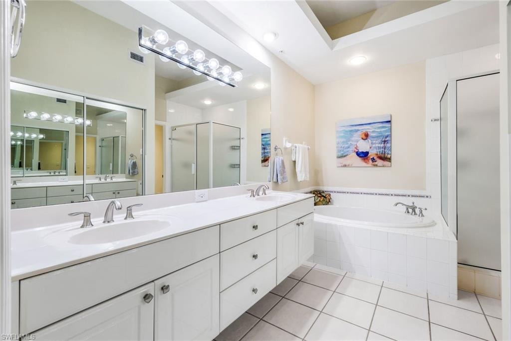 Primary bath with a garden tub, double vanity, a stall shower, light tile patterned floors, and recessed lighting.