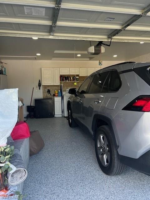 Garage featuring a garage door opener and fridge