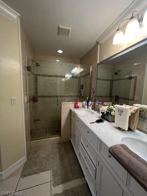 Bathroom with double vanity, a stall shower, and light tile patterned flooring