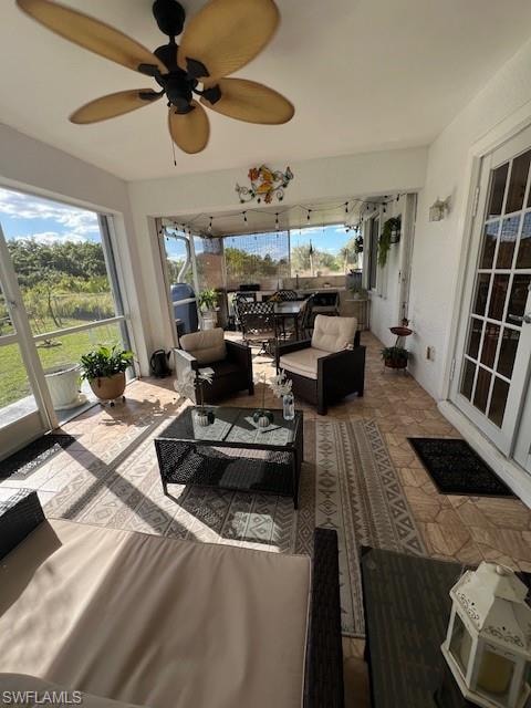 Sunroom with ceiling fan and an outdoor living space
