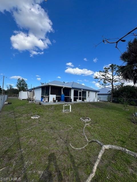 Back of house featuring a fenced backyard and a sunroom