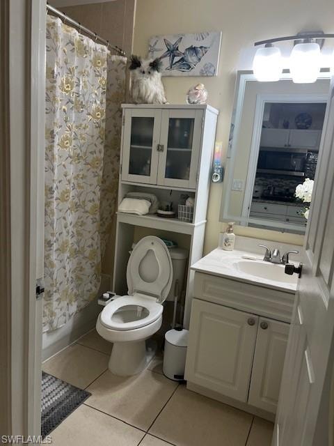 Full bathroom featuring curtained shower, vanity, and light tile patterned flooring