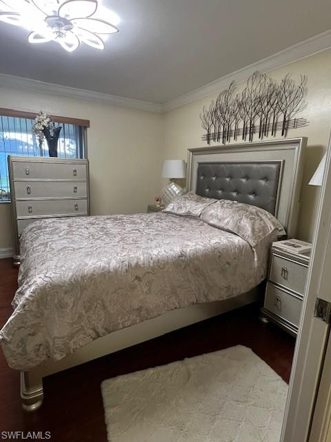 Bedroom featuring dark wood-type flooring and ornamental molding