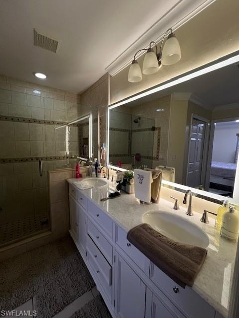 Bathroom featuring double vanity, a shower stall, crown molding, and recessed lighting
