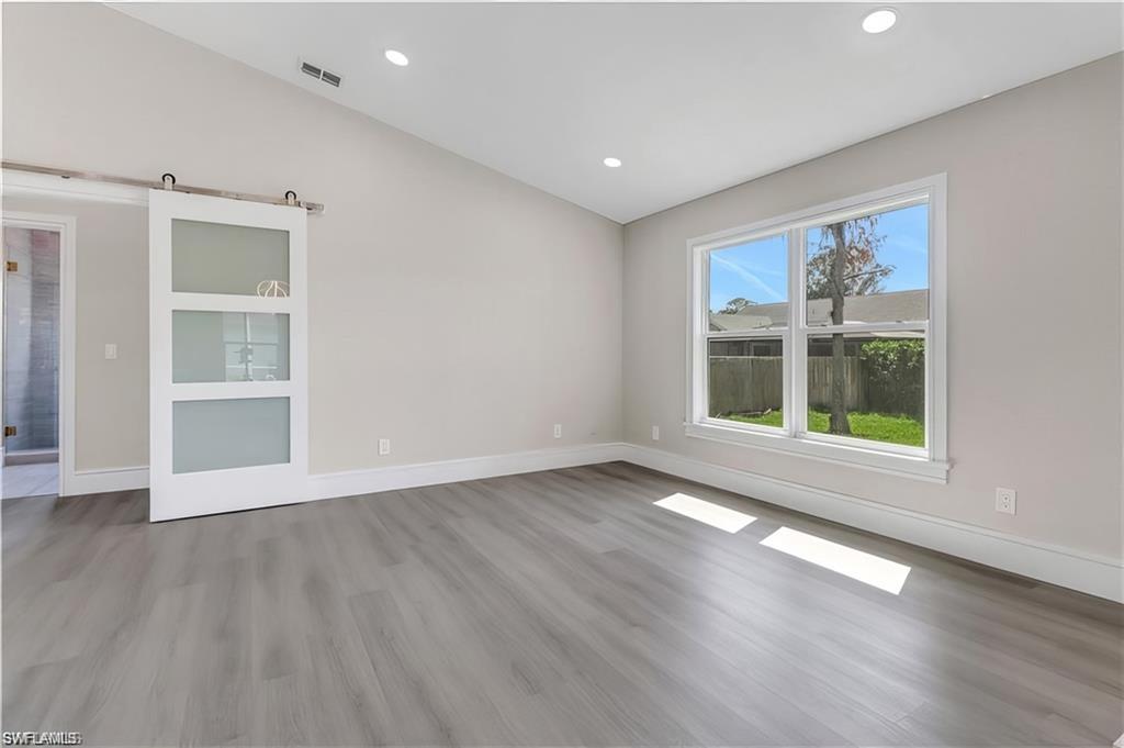 Unfurnished room with light wood-type flooring, vaulted ceiling, and recessed lighting