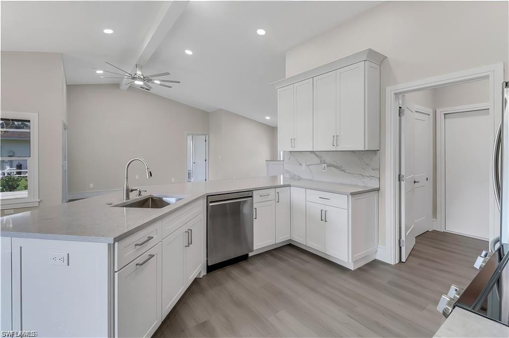 Kitchen featuring stainless steel appliances, light wood-style floors, white cabinetry, a peninsula, and recessed lighting
