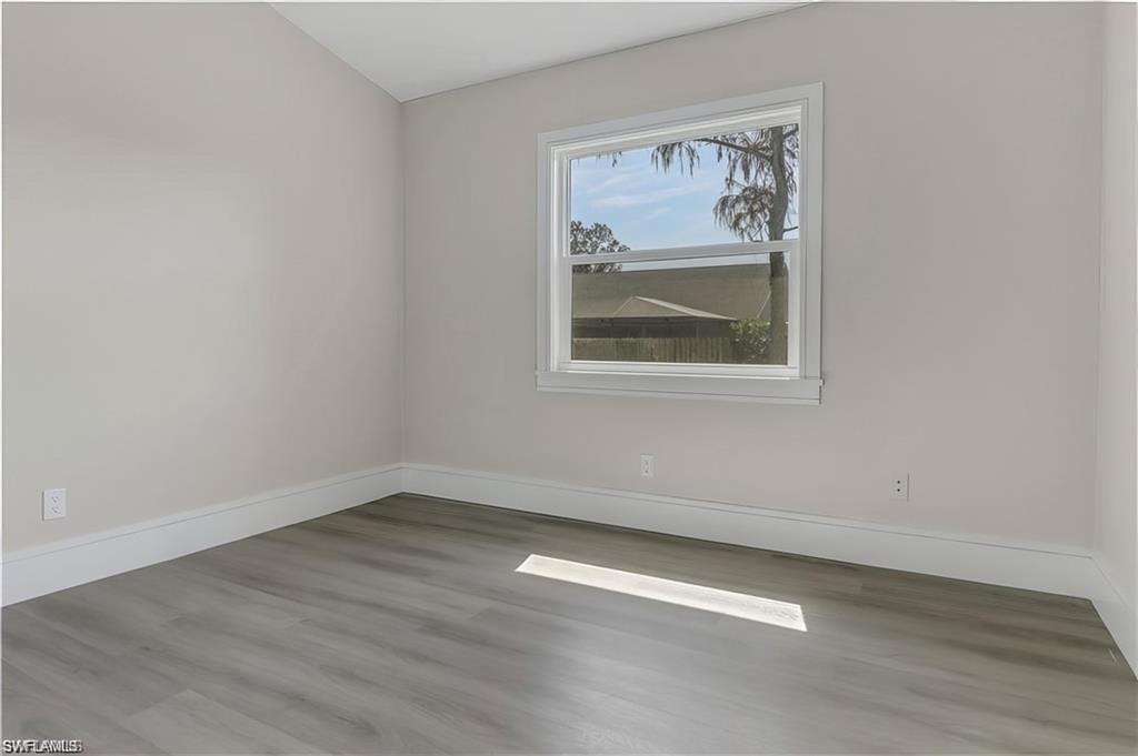 Empty room with baseboards and light wood finished floors