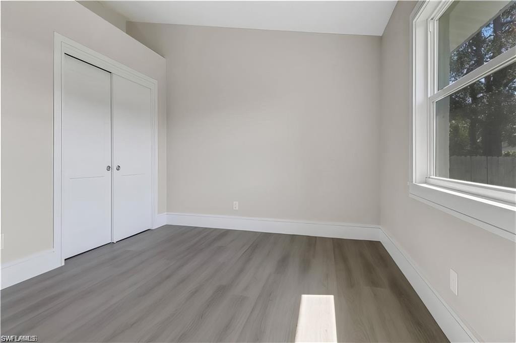Unfurnished bedroom with light wood-style flooring and a closet