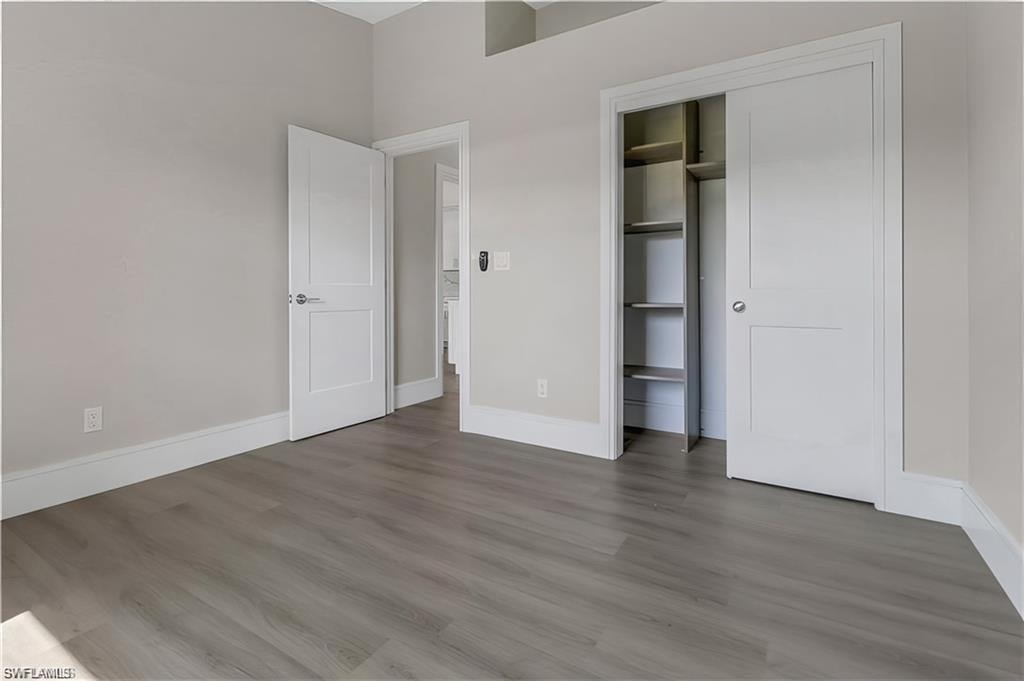 Unfurnished bedroom featuring wood finished floors and a closet