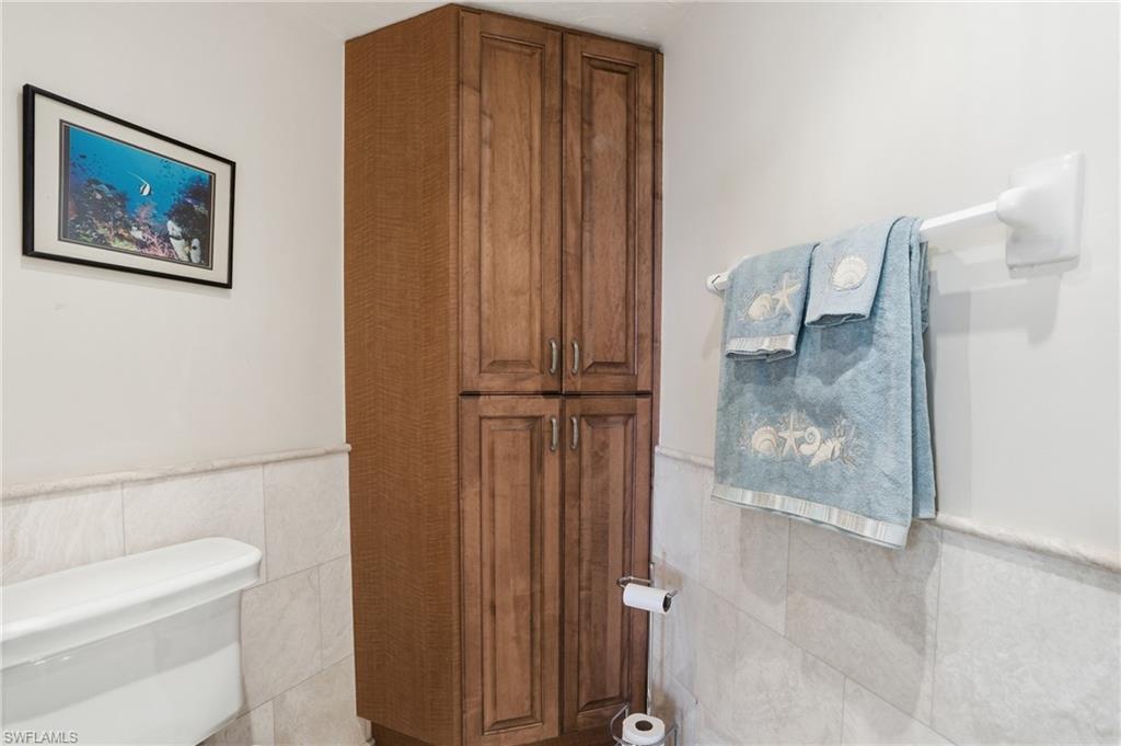 Bathroom with tile walls and a wainscoted wall - Virtually Edited Image