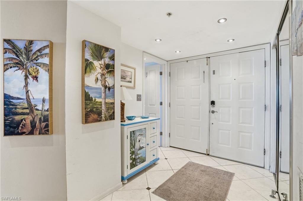 Foyer entrance with light tile patterned floors and recessed lighting - Virtually Edited Image