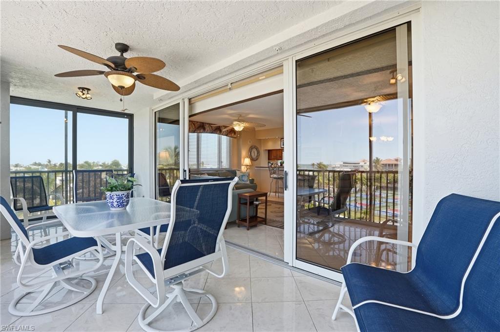 Sunroom / solarium with outdoor dining space and a ceiling fan - Virtually Edited Image