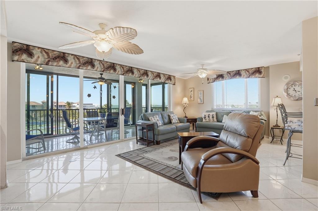 Living room featuring light tile patterned flooring and ceiling fan - Virtually Edited Image