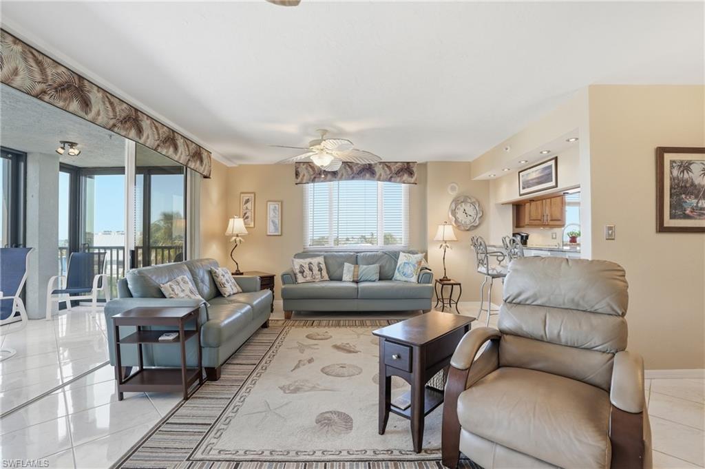 Living area with a ceiling fan and light tile patterned floors - Virtually Edited Image