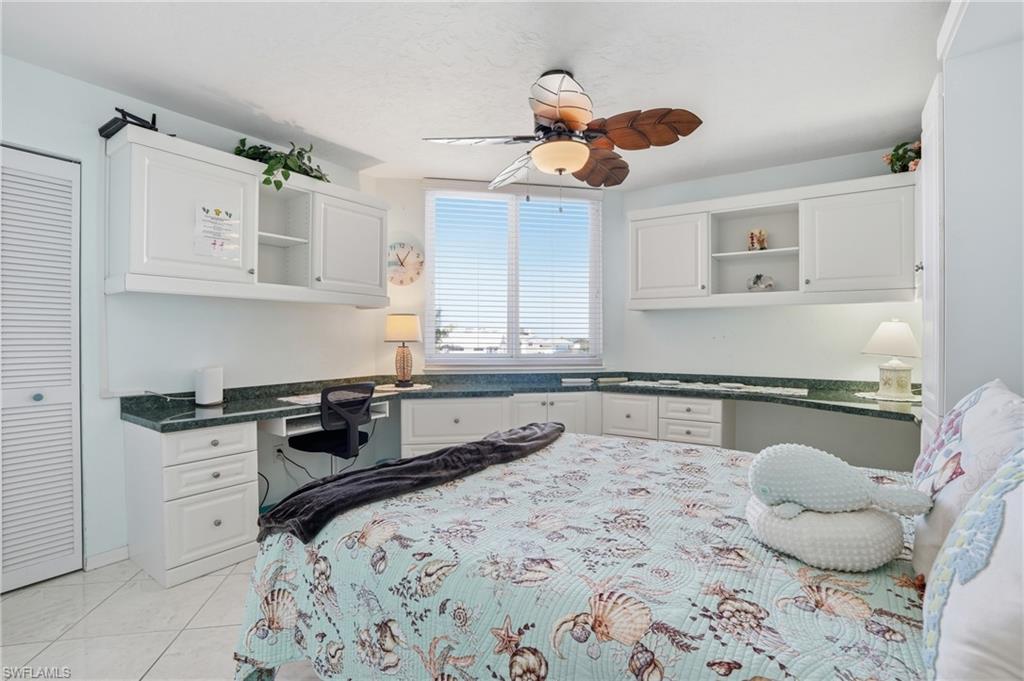 Bedroom featuring built in study area, a ceiling fan, and a closet - Virtually Edited Image