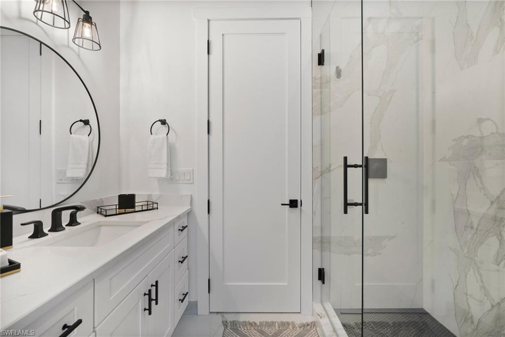 Bathroom featuring vanity and a shower with shower door