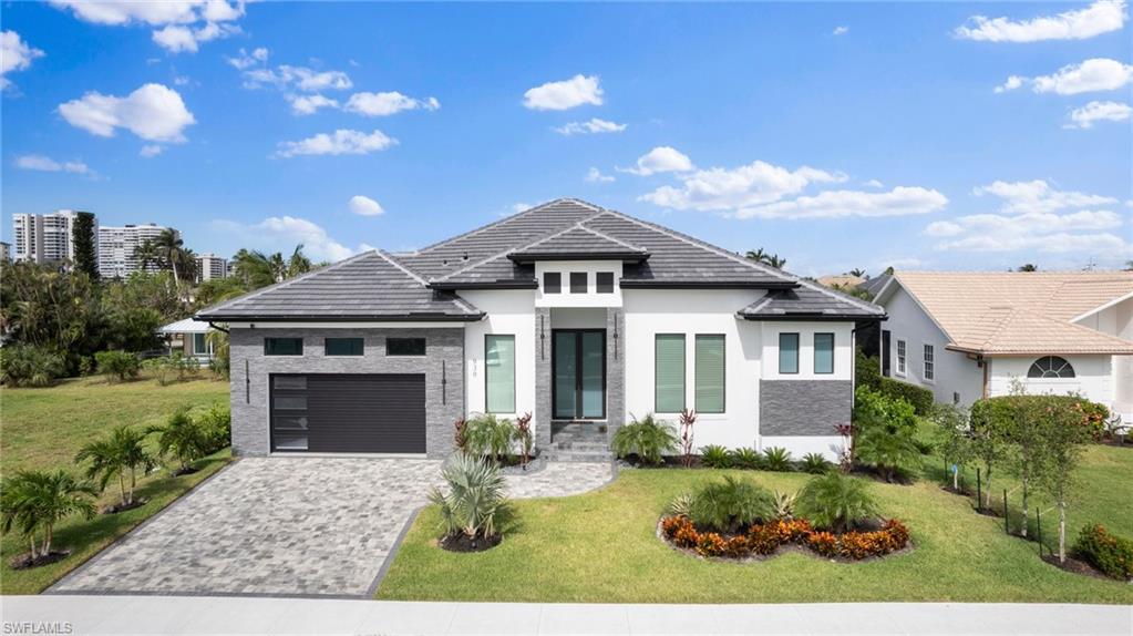 View of front of home featuring a front yard and a garage