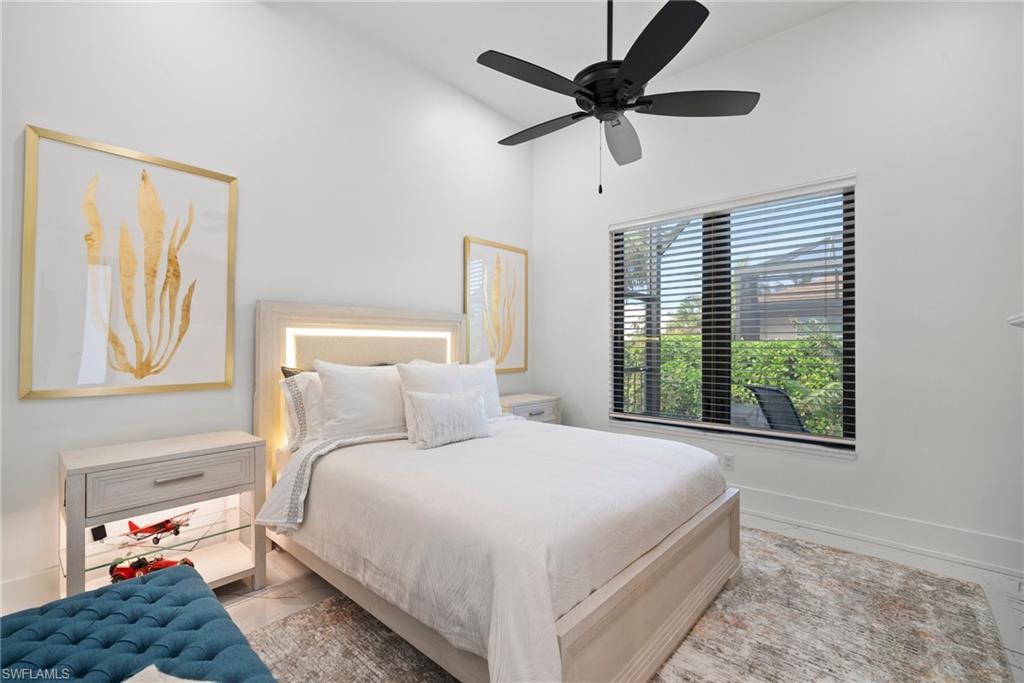 Bedroom with ceiling fan and high vaulted ceiling